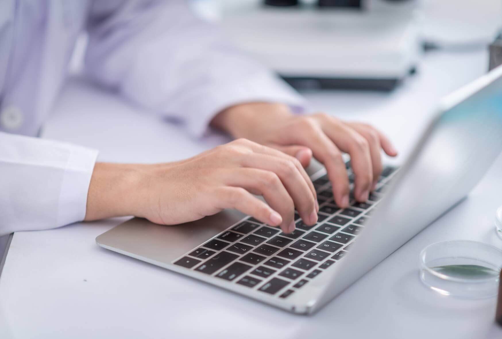 A researchers are analyzing data usinga laptop