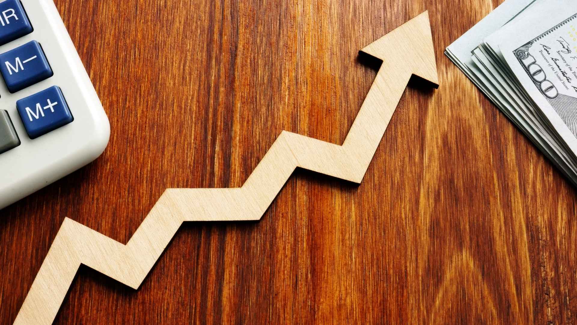 arrow rising, calculator and dollar bills