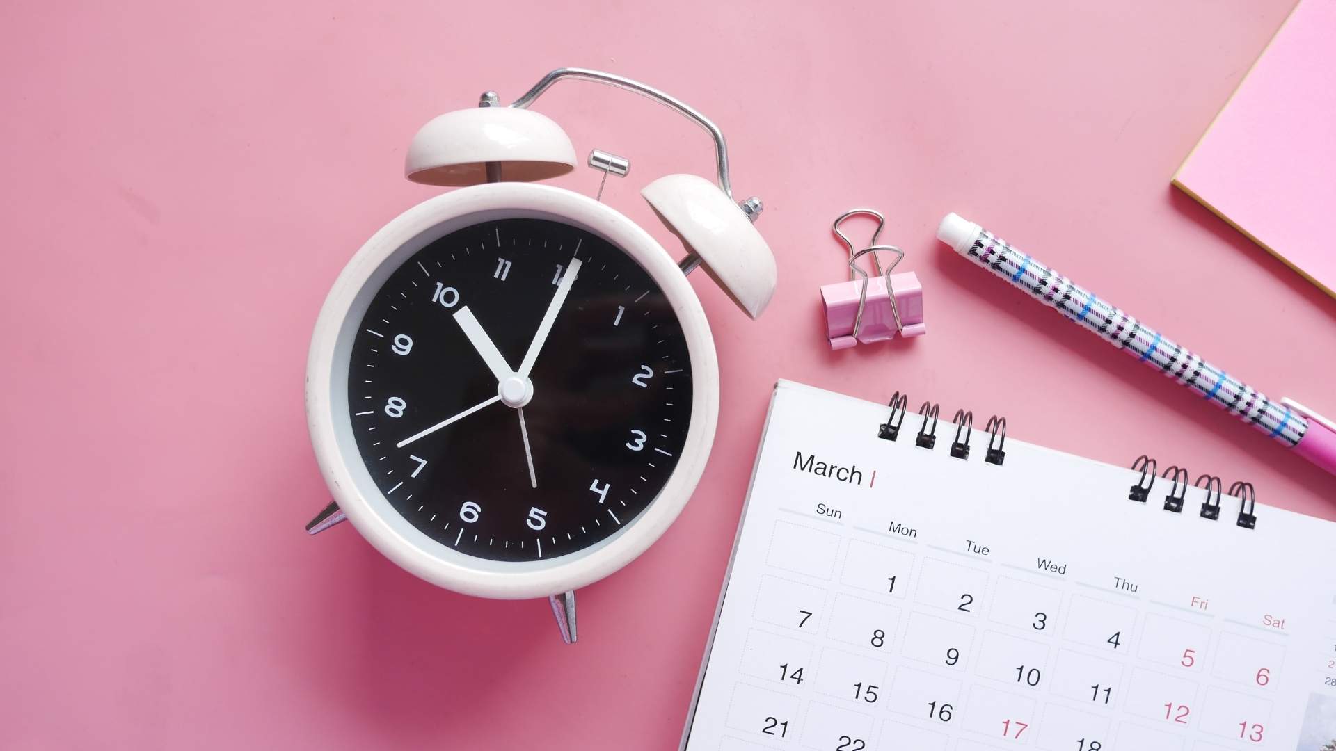 close-up shot of an alarm clock and calendar