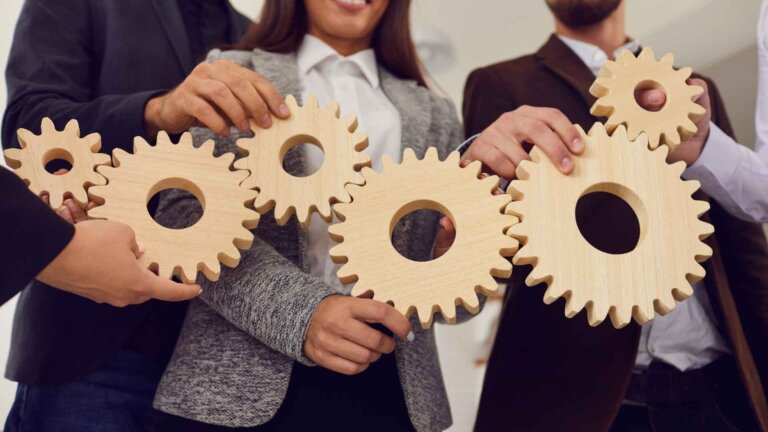 empoyees holding a wooden cogwheels