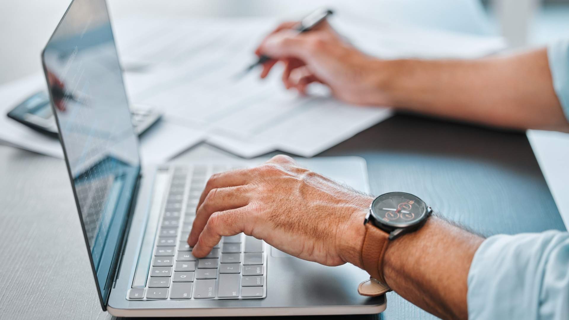 finance person doing the payroll and paperwork on his laptop