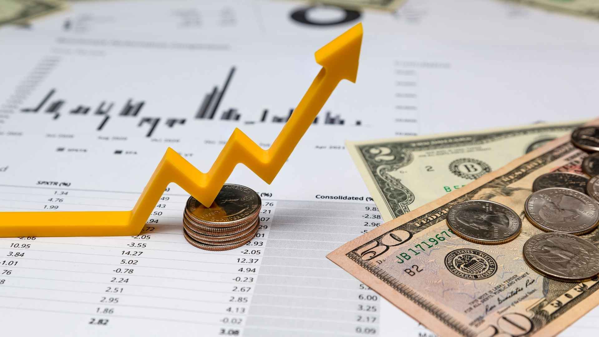 investment report with coins and dollar bills on top