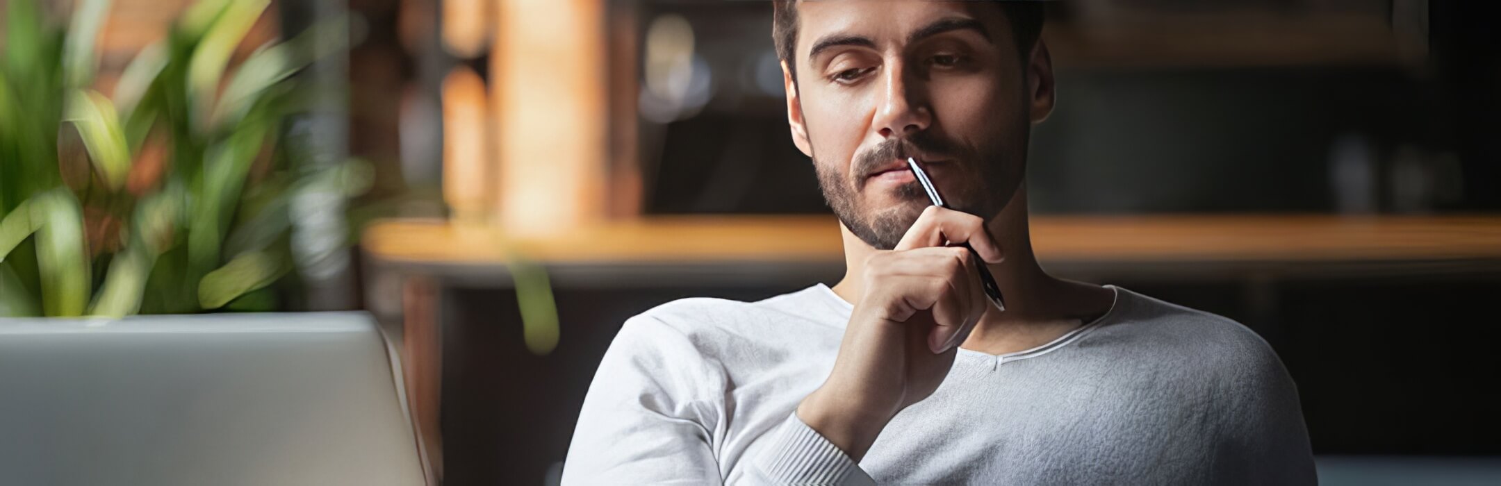 perosn thinking with pen to mouth