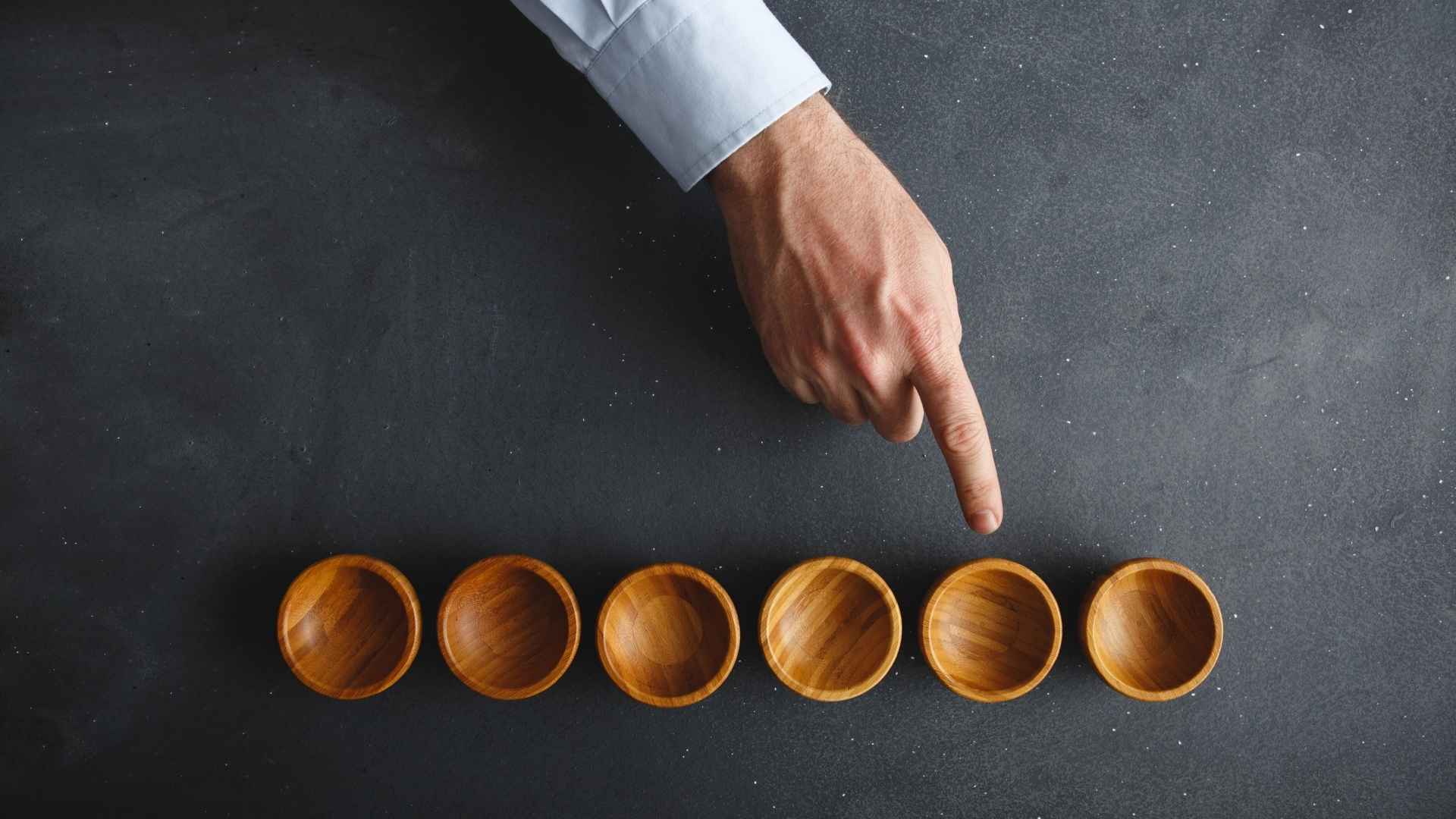 pointing one of the wooden bowl on black desk