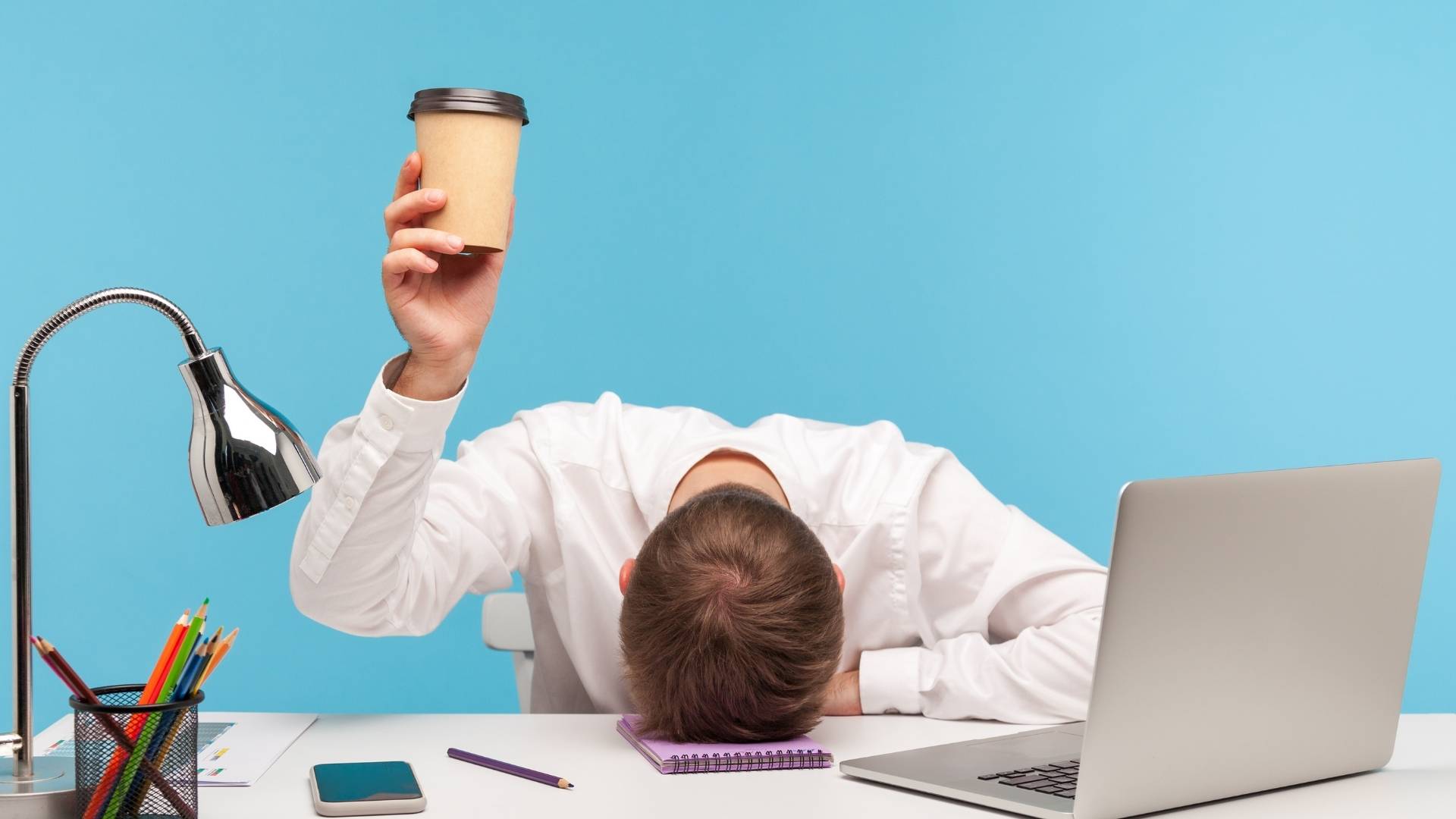 tired freelancer holding a cup of coffee