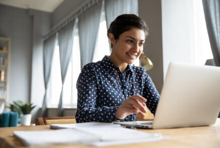 Women wearing full of dots sleeve in front of laptop