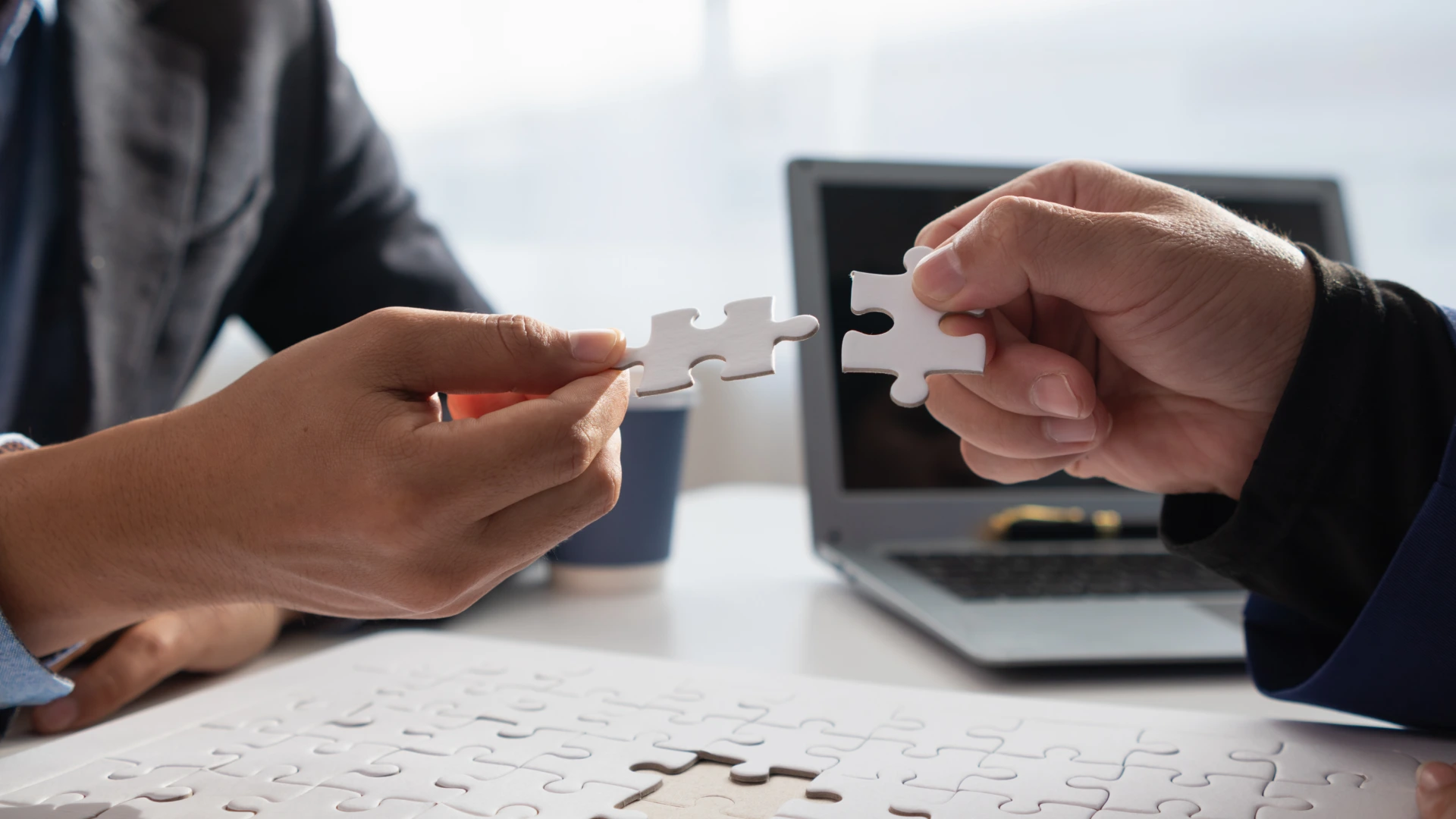 In hands of businessmen and investors they hold jigsaw pieces to put together in right way to make the jigsaw pieces