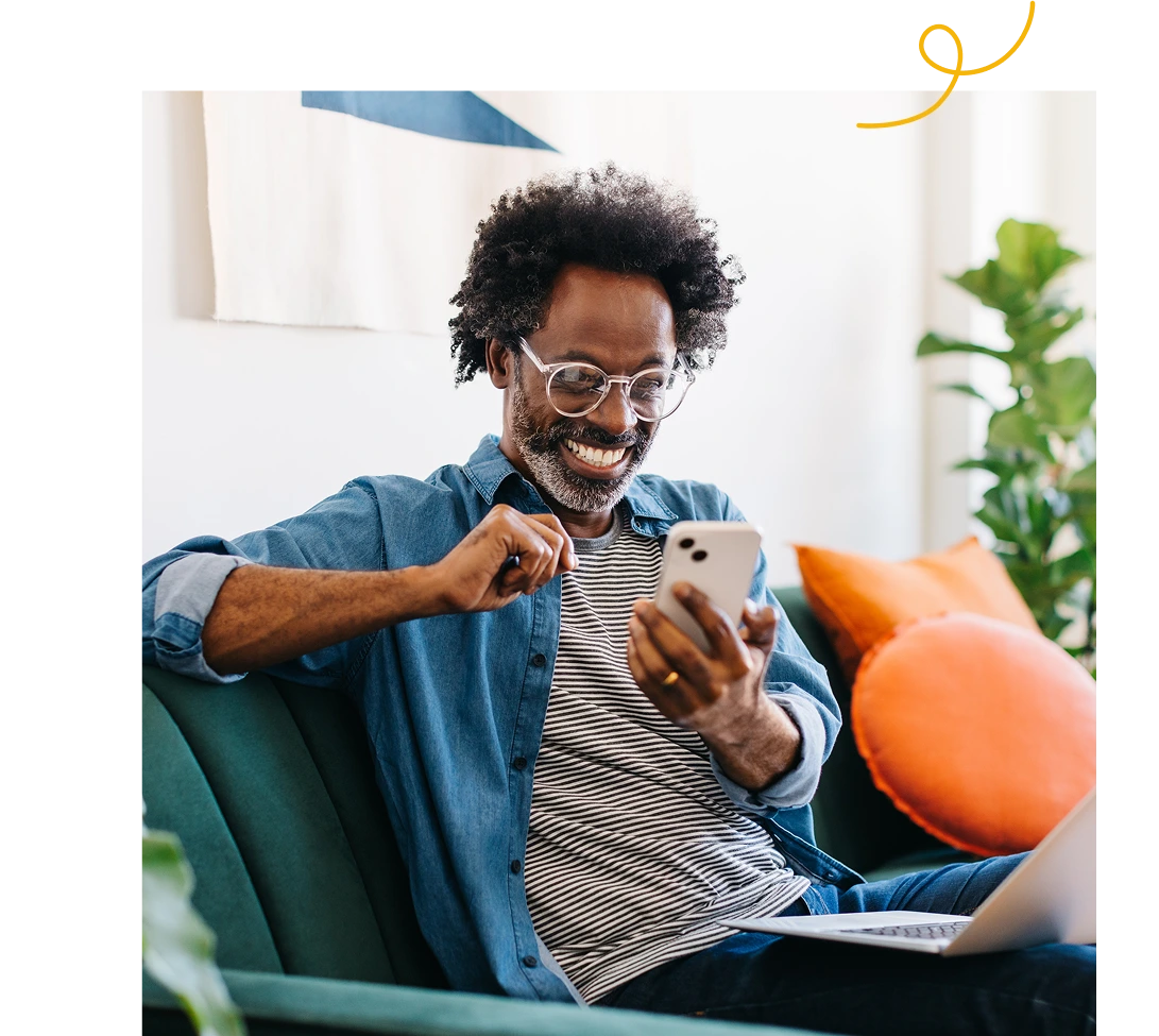 Man Celebrates While Using Smartphone at Home